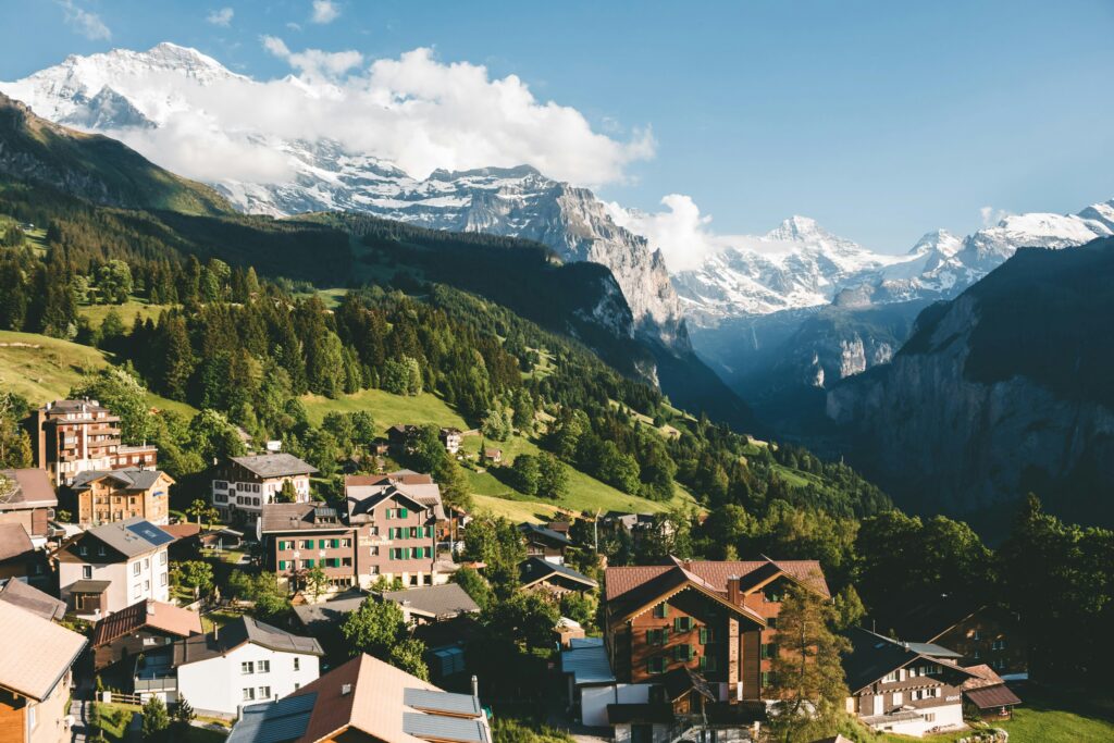 Schweizer Bergdorf Wengen mit Holzhäusern vor schneebedeckten Jungfrau-Alpen im Sommer