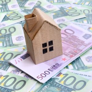 Modellhaus auf Euro-Geldscheinen – Symbolbild für Immobilienfinanzierung und Hauskauf