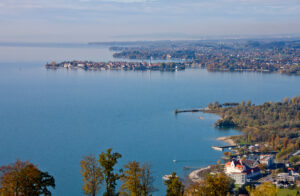 Blick vom Pfänder über den Bodensee auf die Insel Lindau, im Vordergrund das herbstliche Ufer bei Bregenz